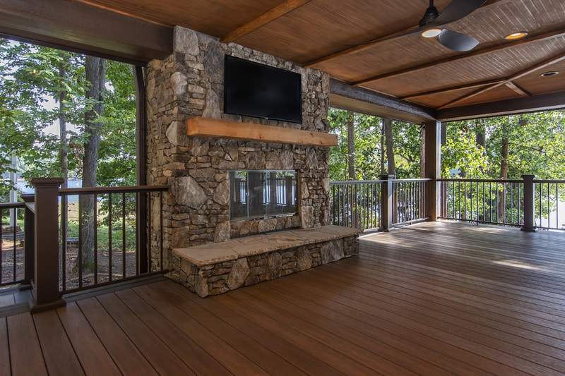 Lake Forest Lodge custom renovation lakeside wrap around covered porch with outdoor fireplace, outdoor lounge, outdoor dining and spectacular views of the lake
