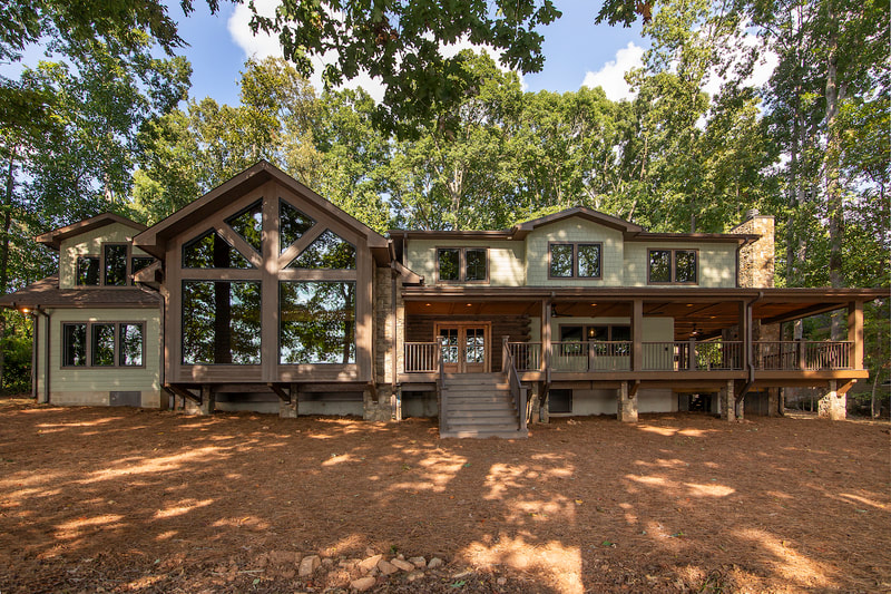 Lake Forest Lodge custom renovation lakeside with wrap around covered deck and large windows with views