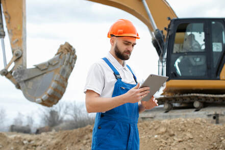 Builder reading regenerative site plan for excavation of new home construction