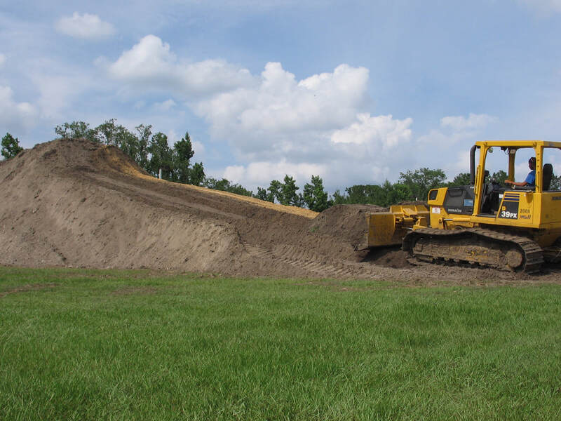 Bulldozer stockpiling soil on a property