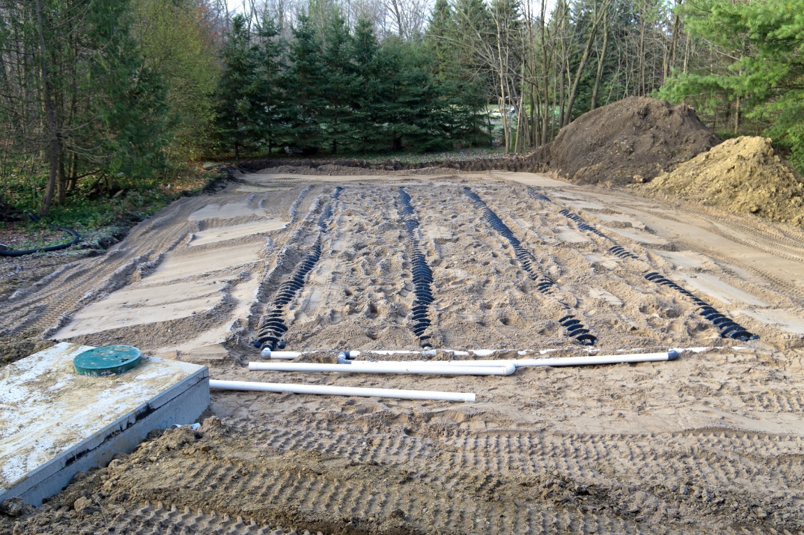 Exposed trenches to drain field of septic system in sandy soil