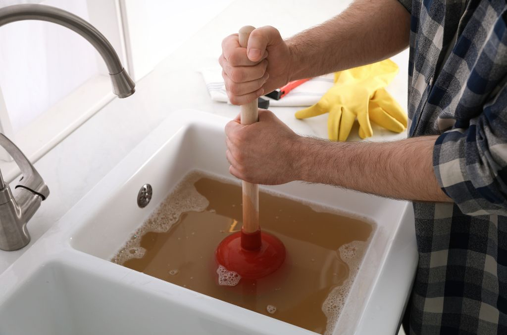 Man plunging a stopped up sink drain