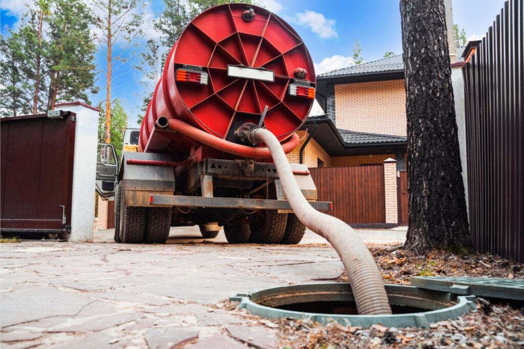 Septic pump truck pumping out home septic tank